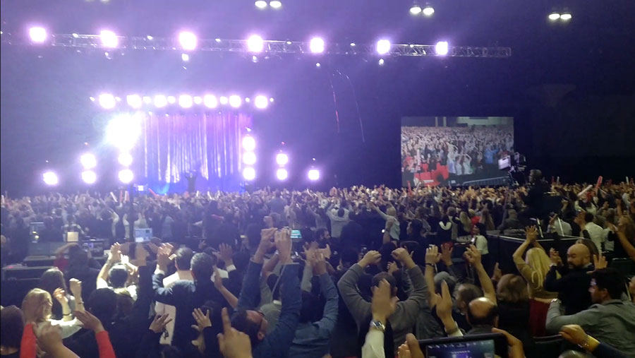 People jumping with their hands in the air at real estate Wealth Expo
